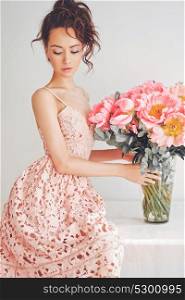 Home stylish fashion photo of beautiful young woman in lace dress with big bouquet of peony. Holidays and Events. Valentine&rsquo;s Day. Spring blossom. Summer season.