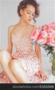 Home stylish fashion photo of beautiful young woman in lace dress with big bouquet of peony. Holidays and Events. Valentine&rsquo;s Day. Spring blossom. Summer season.