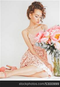 Home stylish fashion photo of beautiful young woman in lace dress with big bouquet of peony. Holidays and Events. Valentine?s Day. Spring blossom. Summer season.