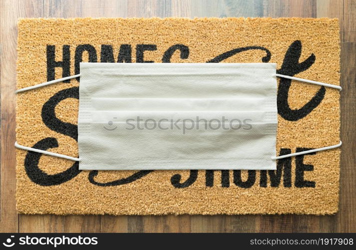 Home Sweet Home Welcome Mat With Medical Face Mask Amidst The Coronavirus Pandemic.