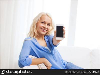 home, technology, advertising and internet concept - smiling woman with blank smartphone screen sitting on couch at home