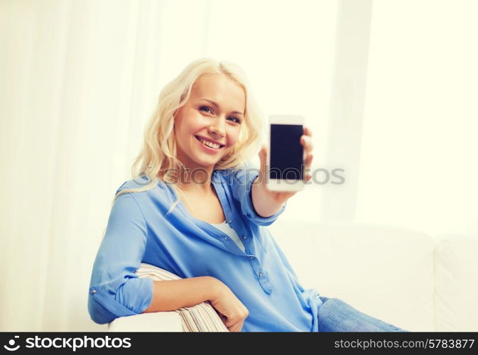 home, technology, advertising and internet concept - smiling woman with blank smartphone screen sitting on couch at home