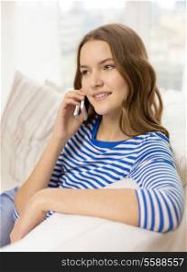 home, technology and communication concept - smiling teenage girl with smartphone sitting on couch at home