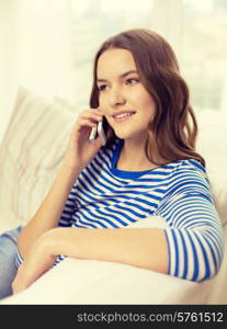 home, technology and communication concept - smiling teenage girl with smartphone sitting on couch at home