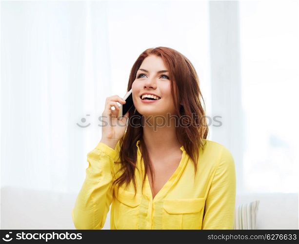 home, technology and communication concept - smiling woman with smartphone sitting on couch at home
