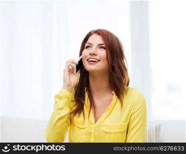 home, technology and communication concept - smiling woman with smartphone sitting on couch at home