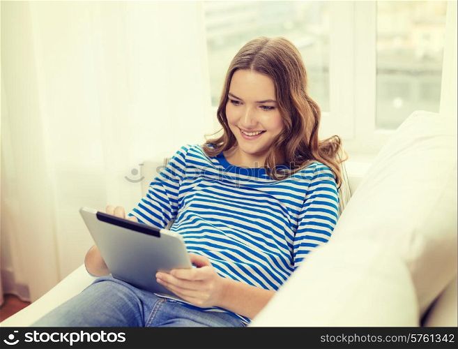 home, technology and internet concept - smiling teenage girl lying on the couch with tablet pc computer at home