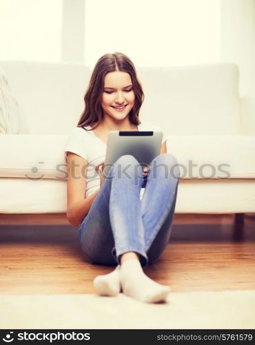 home, technology and internet concept - smiling teenage girl sitting ong the floor with tablet pc computer at home