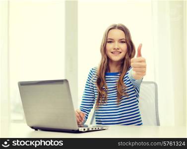 home, technology and internet concept - smiling teenage girl with laptop computer at home showing thumbs up
