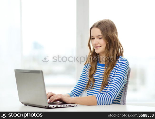 home, technology and internet concept - smiling teenage girl with laptop computer at home