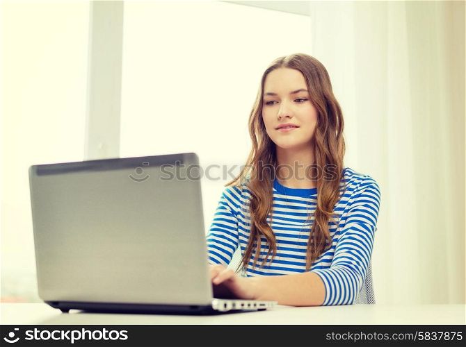 home, technology and internet concept - smiling teenage girl with laptop computer at home