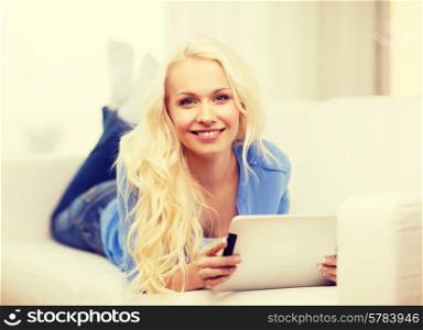 home, technology and internet concept - smiling woman lying on the couch with tablet pc computer at home