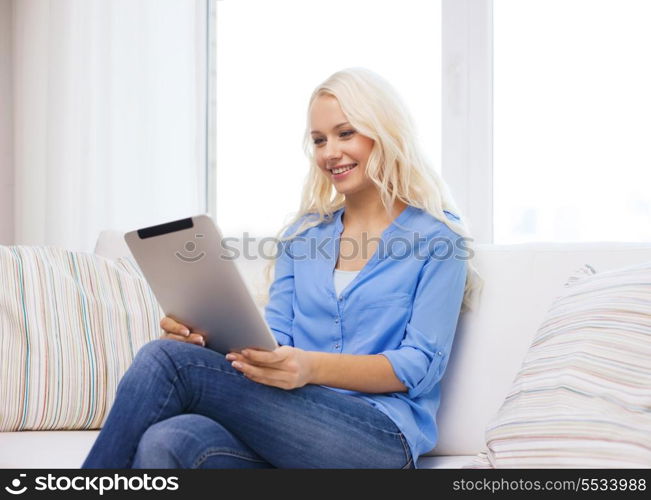 home, technology and internet concept - smiling woman sitting on couch with tablet pc computer at home