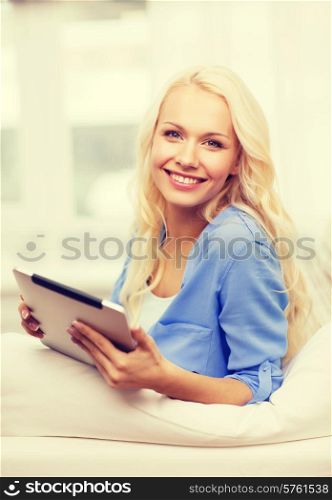 home, technology and internet concept - smiling woman sitting on the couch with tablet pc computer at home
