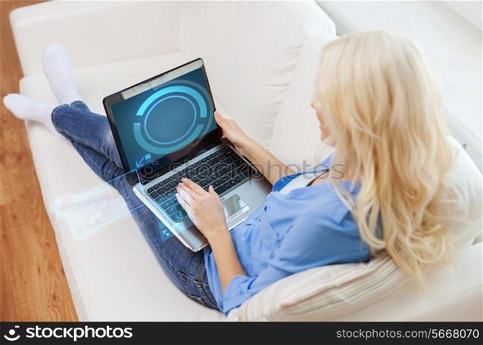 home, technology and internet concept - smiling woman with laptop computer sitting on couch at home