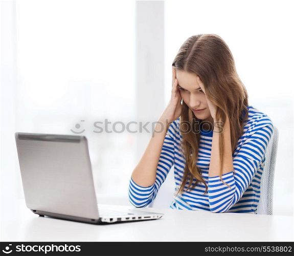 home, technology and internet concept - upset teenage girl with laptop computer at home