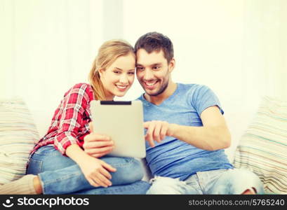 home, technology and relationships concept - smiling couple with tablet pc computer at home