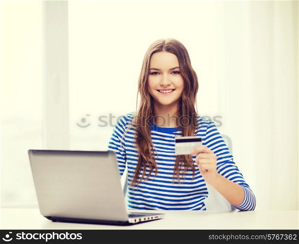 home, technology, banking, money and internet concept - smiling teenage girl with laptop computer and cradit card at home