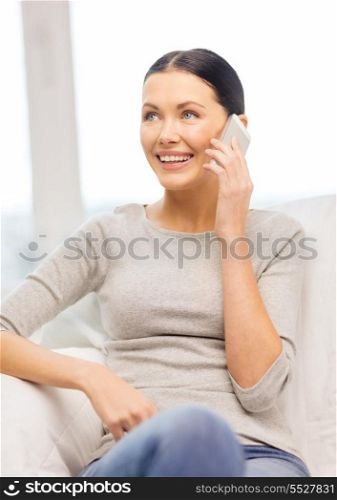 home, technology, communication and internet concept - woman sitting on the couch with smartphone at home