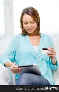 home, technology, online shopping and internet concept - smiling woman sitting on the couch with tablet pc at home