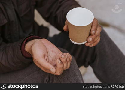 homeless man holding hand out help empty cup