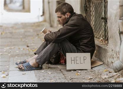 homeless man street with cup help sign