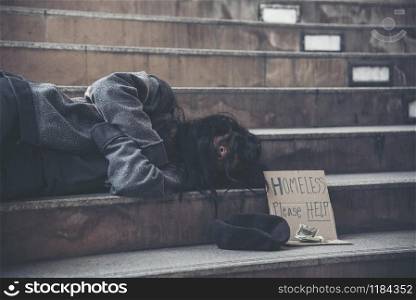 "Homeless people poverty beggar man asking for money job and hoping help in helpless dirty city sitting with sign of cardboard box said "Homeless Please Help" on board. Beggar in city concept."