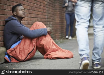 Homeless Teenage Boy In Sleeping Bag On The Street