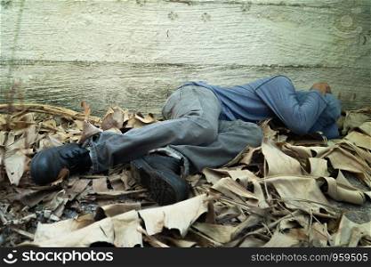 Homeless wore a gray hat and gray long-sleeve shirt. Is sleeping because of exhaustion, with the back leaning against the Siemens wall