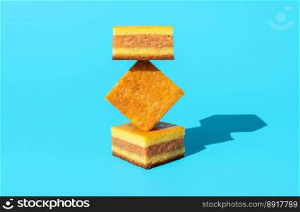 Homemade apple cake in bright light, minimalist on a blue table. Slices of apple cake in an abstract shape stack.