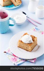 Homemade apple cake, slice with cream on plate, served for tea, selective focus, top view