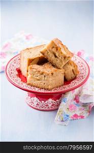 Homemade apple cake, slices on red cakestand, copy space, selective focus
