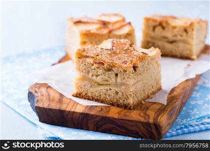 Homemade apple cake, traybake, slices on olive wood background, closeup, selective focus