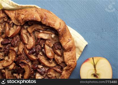 Homemade apple pie with a crispy crust and pecan nuts. Above view with specific autumn sweet food