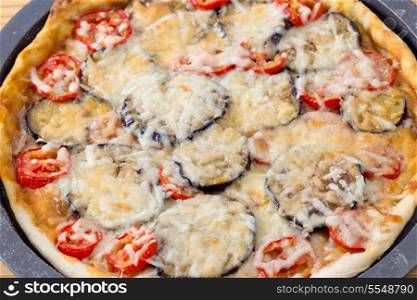 Homemade aubergine, tomato and cheese pizza still in the pan and fresh from the oven