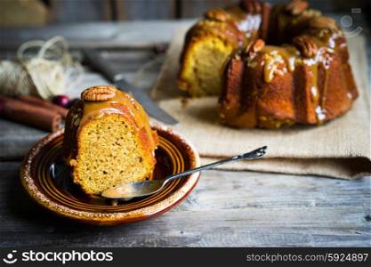 Homemade autumn cake with nuts and caramel on wooden background