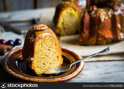 Homemade autumn cake with nuts and caramel on wooden background