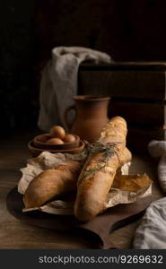 Homemade baguette french bread and herbs on wood table. Bread at wooden tabletop as baking concept