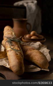 Homemade baguette french bread with parchment paper on wood table. Bread at wooden tabletop as baking concept