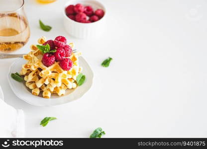 Homemade baked Belgian ricotta waffles with fresh berries on white wooden table