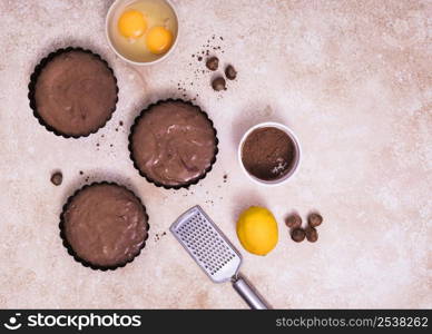 homemade baked cakes with egg yolk hazelnut whole lemon hand grater against textured background