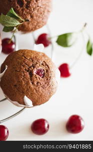 Homemade baked cherry muffins with fresh berries on white wooden table. Top view