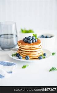 Homemade baked ricotta pancakes with fresh berries on white wooden table