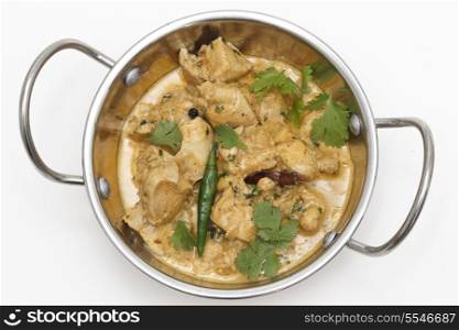 Homemade balti chicken pasanda, made with spices, yoghurt, cream and chopped coriander and chillies seen from above in a kadai (or karahi or wok) serving bowl, garnished with cilantro leave and a green chilli pepper
