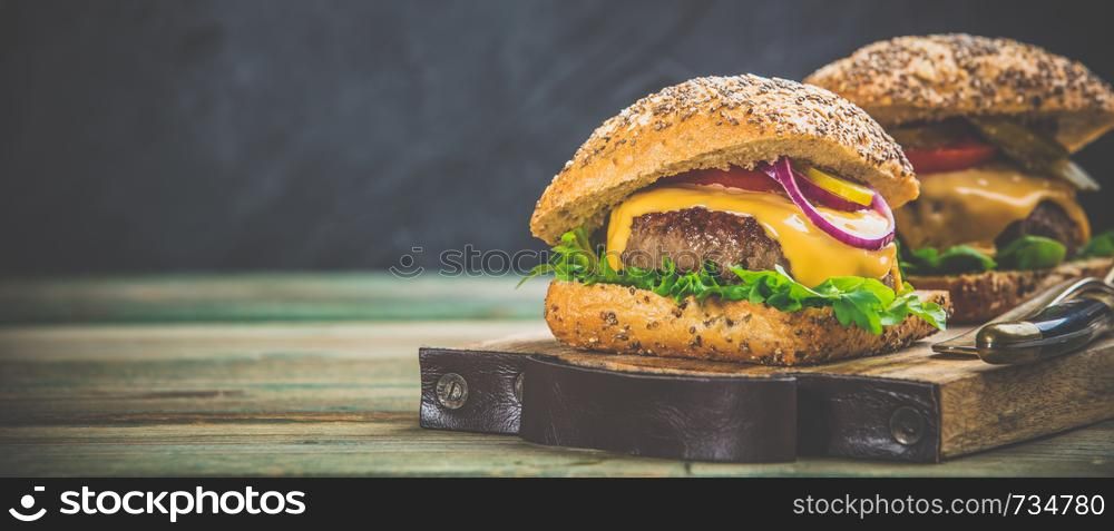 Homemade beef and ciabatta hamburgers on wooden background, space for text. Homemade hamburgers on wooden background, space for text