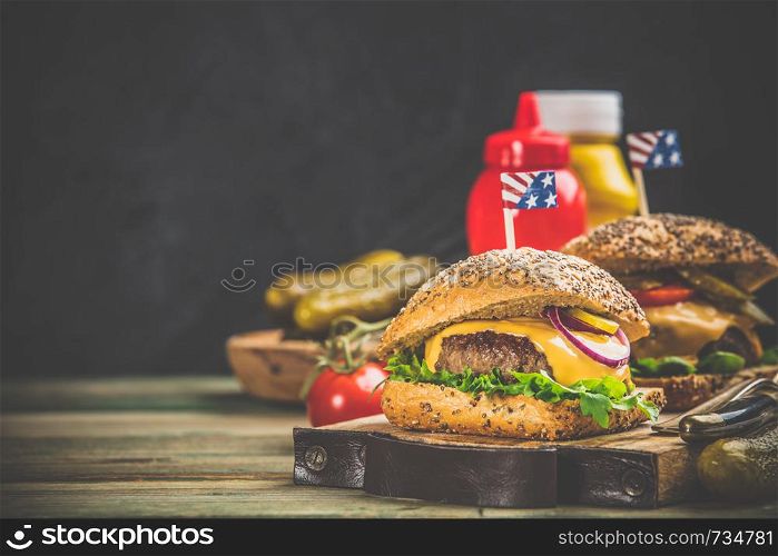 Homemade beef and ciabatta hamburgers on wooden background, space for text. Homemade hamburgers on wooden background, space for text