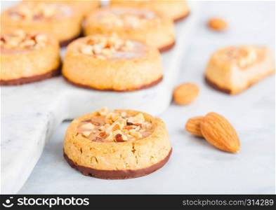 Homemade biscuit cookies with almond nuts and peanut butter on marble board on kitchen table background.