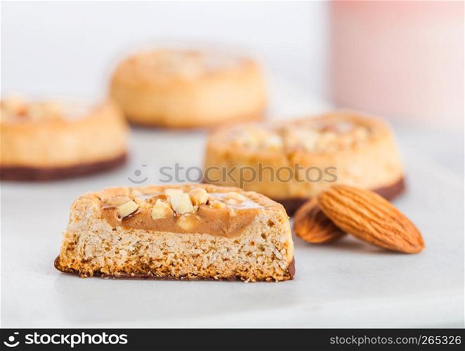 Homemade biscuit cookies with almond nuts and peanut butter on marble coasters on kitchen table background.