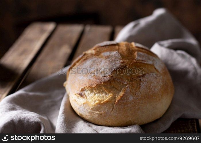Homemade bread and cloth napkin on table. Bakery concept at wood tabletop
