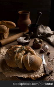 Homemade bread with parchment paper on wood table. Bread at wooden tabletop as baking concept